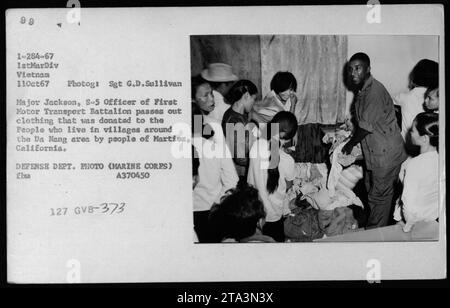 Major Jackson, S-5 Officer of First Motor Transport Battalion, distributes clothing donated by the people of Martinez, California to villagers in the Da Nang area of Vietnam. This effort aimed to support and improve the living conditions of local residents during the war. Stock Photo