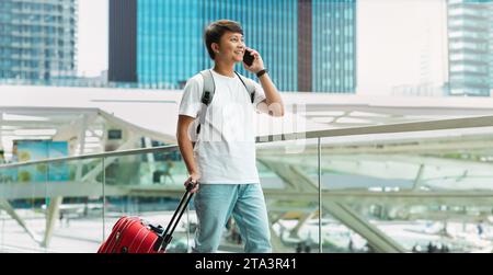 Handsome Young Asian Man Talking On Cellphone In Airport Stock Photo