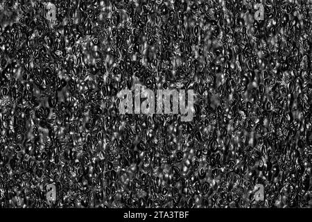 Black Expanded polyethylene foam sample background. EPE beads packing material with macro details, textures and one solid color. Stock Photo