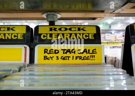 Clearance label in the Amoeba Music store used CD section for the rock music genre; red tag sale, but three get one free; San Francisco, California. Stock Photo