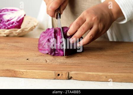 Close Up Female Hand Sliced Purple Cabbage, Step by Step Cooking in the Kitchen Stock Photo