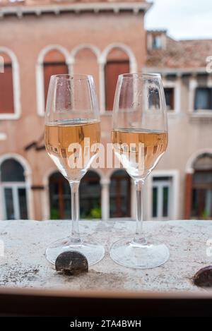 Romantic evening with wine glasses overlooking mysterious and alluring cityscape at dusk. Stock Photo