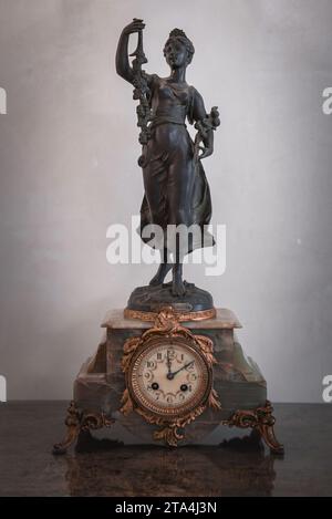 Ornate statue of woman holding decorative clock on pedestal in luxurious Venetian style Stock Photo