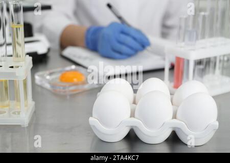 Scientist proceeding quality control in laboratory, focus on fresh eggs Stock Photo