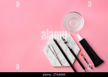 Flat lay composition with eyebrow henna and tools on pink background. Space for text Stock Photo