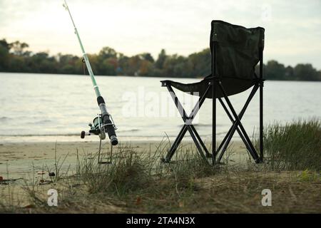 Camping chair with fishing rod at riverside on sunny dayの素材  [FY310206085742]