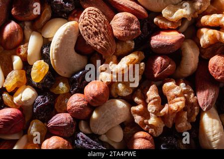 Mixed Nuts: Almonds, Walnuts, Cashews, Peanuts, Hazelnuts, Dried Prunes and Raisins. Different Nut Mix. Background from Various Nuts and Dried Fruits Stock Photo