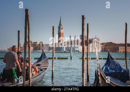 Tranquil Venice: Serene Gondolas on Calm Water with Traditional Architecture in Background Stock Photo