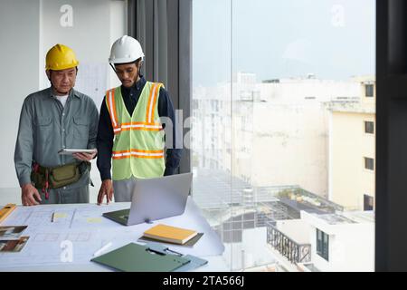 Team of construction workers having video call with foreman Stock Photo
