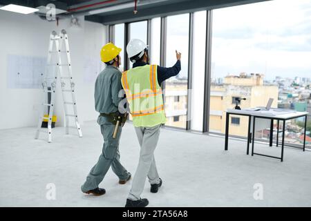 Engineer and contractor discussing how to build room divider Stock Photo