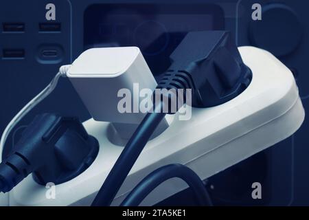 The Socket Tee With Connected Plugs. The Charging Station Electric Power Supply For Blackout. Electricity Household Equipment, Selective Focus. Stock Photo