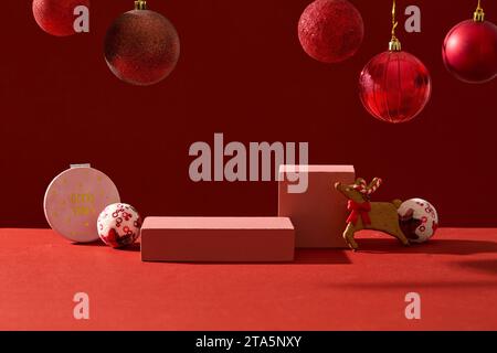 Advertising photo with Christmas decorations concept. Front view of empty rectangular podiums displayed on red background with twinkle red baubles Stock Photo