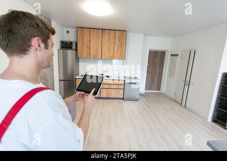 Worker with tablet computer checking alarm system indoors. Stock Photo