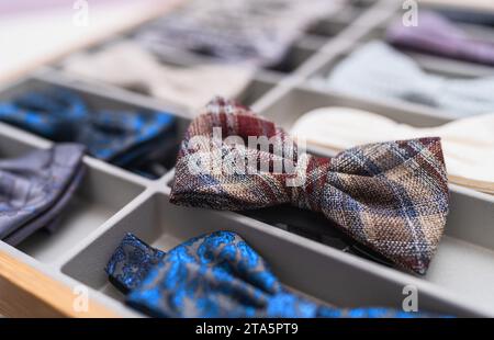 Assorted bow ties displayed in organizer, focus on plaid bow tie in foreground at a store Stock Photo