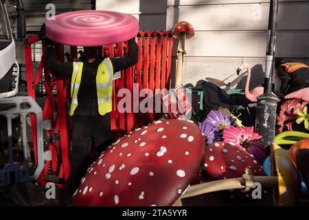 A work crew organises and carries fibreglass props including toadstools, flowers and flamingos into a venue for a forthcoming event promoting the new Willy Wonka film in Bloomsbury, on 28th November 2023, in London, England. 'Wonka' is a movie production scheduled to be released in the UK on 8 December and in the US on 15 December, by Warner Bros. Pictures. Stock Photo