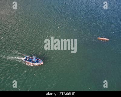 An aerial view of a launch and a rowing gig heading out across the sea just off Exmouth, seen from above Dawlish Warren, Devon, Great Britain. Stock Photo