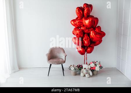 Lots of red heart-shaped balloons in a white room Stock Photo