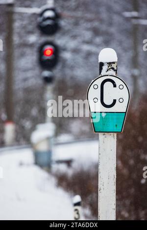 Russian railway Sign C - sound signal, semaphore shows red stop signal on a background. Vertical photo taken on a snowy winter day Stock Photo