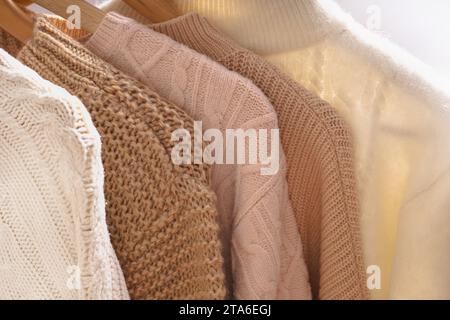 Winter sweaters hang in a row on a hanger, shoulders close-up. Stock Photo