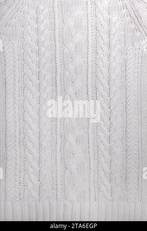 The texture of a white knitted sweater in close-up. Stock Photo