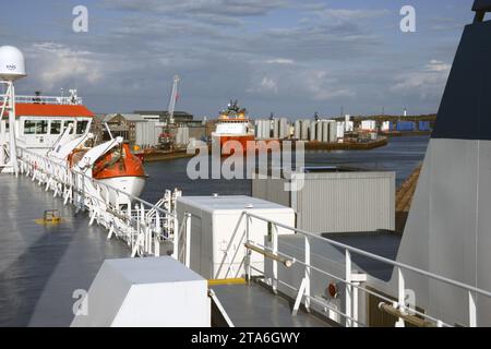 View on board the ferry in Aberdeen Harbour in Aberdeenshire, Scotland with ships waiting alongside the harbour walls. Stock Photo