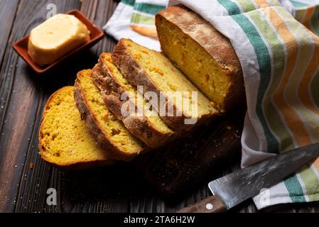 Homemade cornbread slices and butter on kitchen table Stock Photo