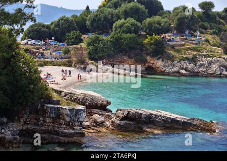 CORFU, GREECE - MAY 31, 2016: People enjoy the beach in Kassiopi, Corfu Island, Greece. 558,000 tourists visited Corfu in 2012. Stock Photo
