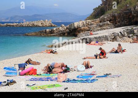 CORFU, GREECE - MAY 31, 2016: People enjoy the beach in Kassiopi, Corfu Island, Greece. 558,000 tourists visited Corfu in 2012. Stock Photo