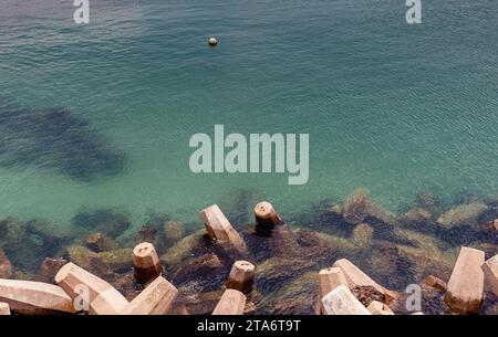 Panoramic photo of sea ocean coastline concrete wave breakers at harbour edge in Mosselbay, South Africa - breakwater tetrapod maritime infrastructure Stock Photo