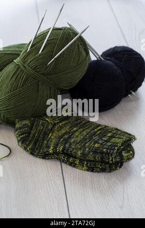 wool yarn, knitting needles and other tools for hand knitting, on a wooden table. Stock Photo