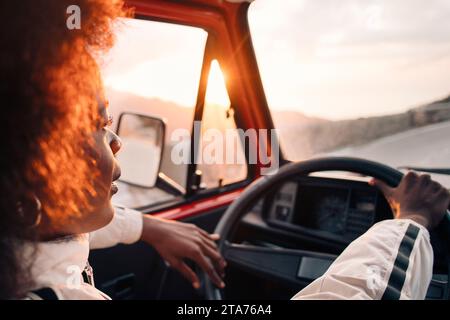 Young man driving van at sunset on vacation Stock Photo
