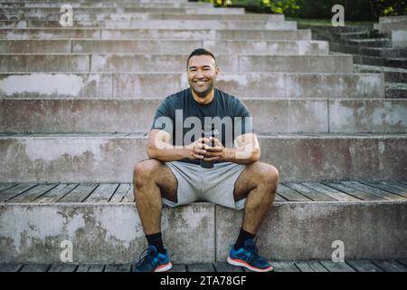 Portrait of smiling man sitting on steps Stock Photo