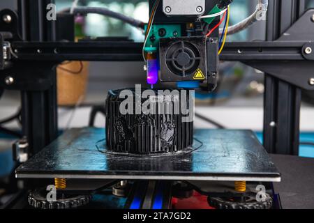 A 3D printer prints a black model. Technology at home Stock Photo