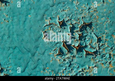 Blue peeling paint on the wall. Old concrete wall with cracked flaking paint. Weathered rough painted surface with patterns of cracks and peeling. Hig Stock Photo