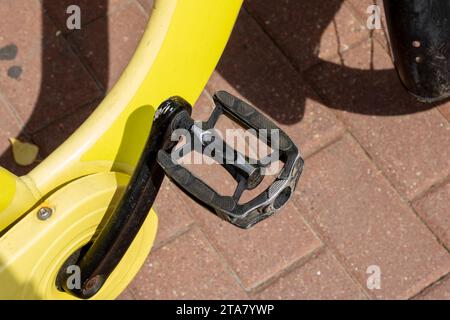 Pedal of yellow Bike on sidewalk close up Stock Photo
