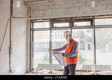 The foreman at the construction site is carefully studying the project, controlling the process of work execution. Stock Photo