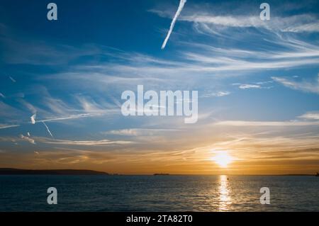 Sunset Over The Solent Looking Towards The Needles, Isle OF Wight And Hurst Castle With Cirrus Uncinus, Mares Tail Clouds, Solent UK Stock Photo