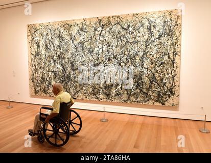 New York, USA - May 25, 2018: A man in wheelchair looks at the Jackson Pollock painting in Museum of Modern Art in New York City. Stock Photo