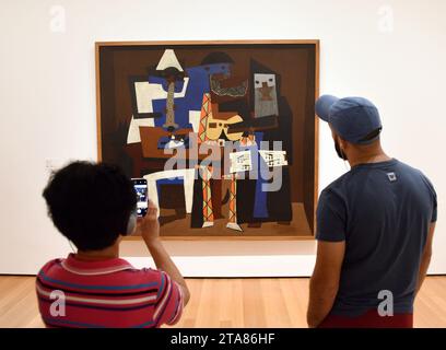 New York, USA - May 25, 2018: A visitors near the Pablo Picasso Three Musicians painting in Museum of Modern Art in New York City. Stock Photo