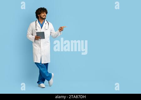 Handsome indian doctor using digital tablet to conduct remote appointments Stock Photo