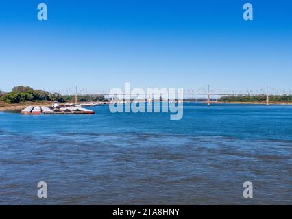 Barges wait at the confluence of the blue Ohio river and brown Mississippi river at Cairo with blue and brown muddy streams mixing Stock Photo