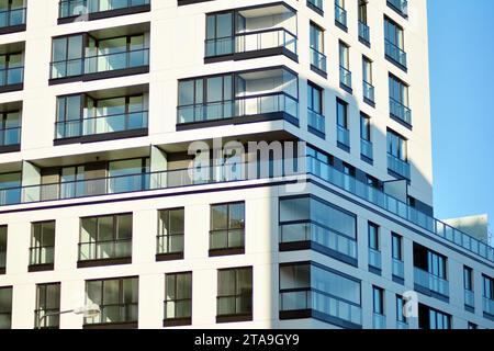 New apartment building with glass balconies. Modern architecture houses by the sea. Large glazing on the facade of the building. Stock Photo