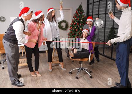 Happy colleagues having fun at New Year party in office Stock Photo