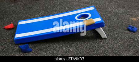 Blue and white cornhole game on a tar street Stock Photo