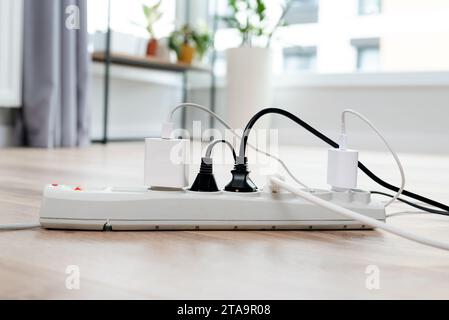 Electric plug put on multiple socket. Electrical equipment, electrical wires and power strips in the house Stock Photo