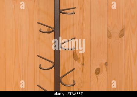 Metal structure clothes hanger hooks on wooden background close-up. Stock Photo