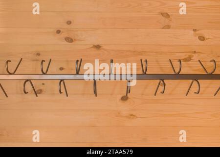 Metal structure clothes hanger hooks on wooden background close-up wardrobe. Stock Photo