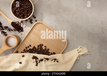 Brown roasted coffee beans decorated with beige cloth and wooden props on cement background. Space for cosmetic product mockup. Product and promotion Stock Photo