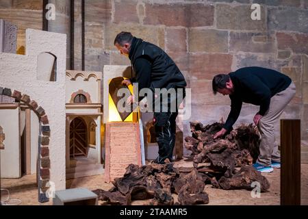 Bamberg, Germany. 29th Nov, 2023. Sacristan Sebastian Dornheim (l) sets up the nativity scene together with Dirk Hirsch (r). The nativity scene is set up in Bamberg Cathedral. The crib is used to depict the biblical Christmas story. This is shown in weekly changing scenes. Credit: Daniel Vogl/dpa/Alamy Live News Stock Photo