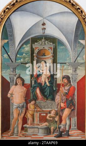 TREVISO, ITALY - NOVEMBER 8, 2023: The renaissance painting of Madonna with the St. Sebastian and St. Roch in the Cathedral. Stock Photo